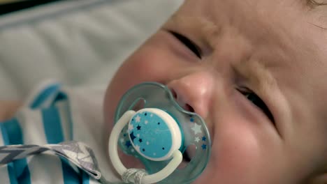 Portrait-of-cute-baby-with-dummy-is-crying