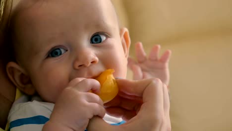 Retrato-de-bebé-encantador-está-comiendo-un-albaricoque