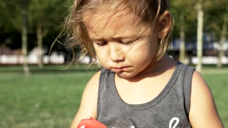 Hermosa-niña,-comiendo-sandía-en-el-parque-de-verano-de-la-ciudad