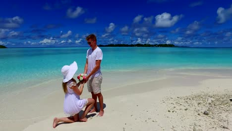 v07391-Maldives-white-sandy-beach-2-people-young-couple-man-woman-proposal-engagement-wedding-marriage-on-sunny-tropical-paradise-island-with-aqua-blue-sky-sea-water-ocean-4k