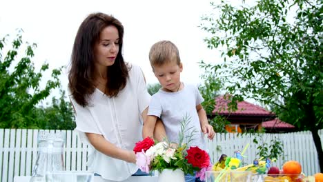 Sommer-im-Garten.-Mutter-mit-einem-vier-Jahre-alten-Sohn-machen-einen-Blumenstrauß.-Der-junge-mag-sehr,-er-glücklich,-es-ist-Spaß,-verbringt-die-Familie-ihre-Freizeit-zusammen