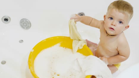 Niño-lindo-juega-con-las-toallas-en-el-baño