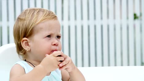 summer,-in-the-garden,-funny-one-year-old-blond-girl-eating-watermelon