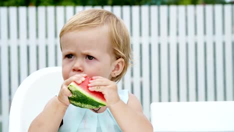 Sommer-in-den-Garten,-lustige-One-jährige-blonde-Mädchen-Wassermelone-essen