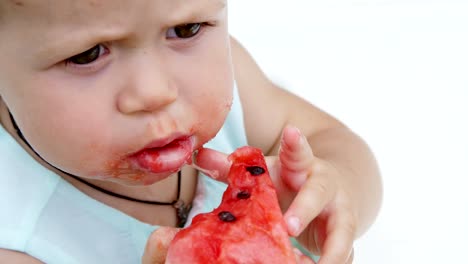 summer,-in-the-garden,-funny-one-year-old-blond-girl-eating-watermelon