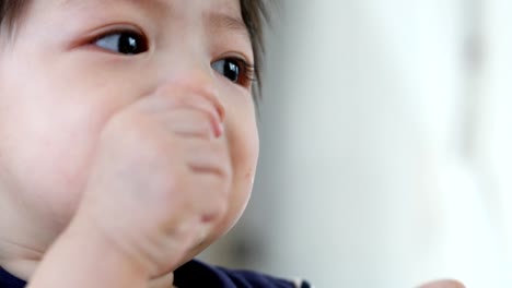 niedliche-Baby-Kind-mit-Finger-Hand-im-Mund-juckende-Zahnfleisch