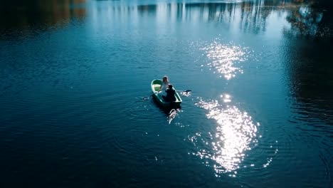 Jóvenes-novios-nadando-a-bordo-en-el-lago-hermoso.-Vista-aérea