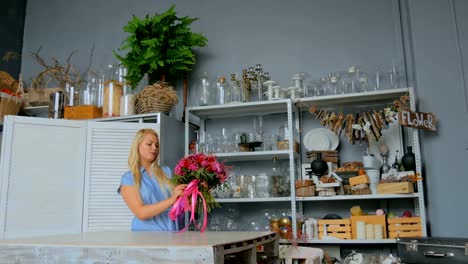 Professional-florist-holding-and-checking-bouquet-at-studio