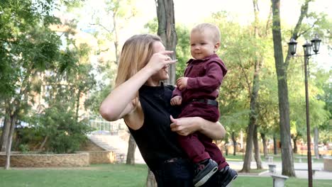 mum-tickles-and-playing-with-her-son,-baby-laughing-in-hands-of-mother