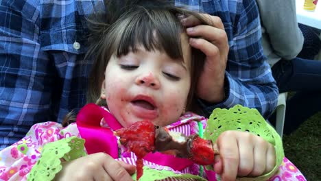 Candid-moment-of-little-girl-eating-chocolate-strawberry-sweet