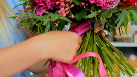 Professional-florist-holding-and-checking-bouquet-at-studio