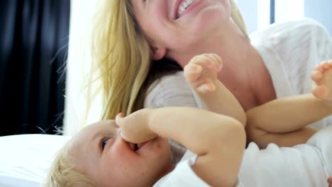 Portrait-of-mother-kissing-her-baby-girl-indoor