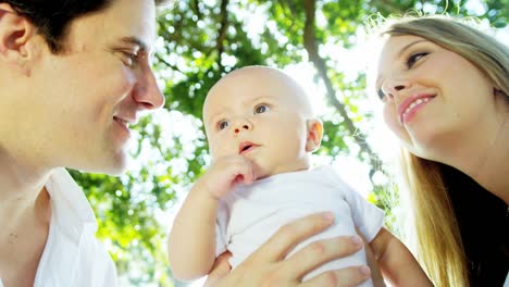 Retrato-de-caucásicos-padres-con-bebé-al-aire-libre