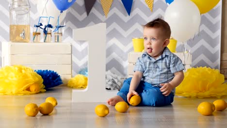 The-boy-is-playing-with-the-lemon.-He-is-trying-to-taste-it.