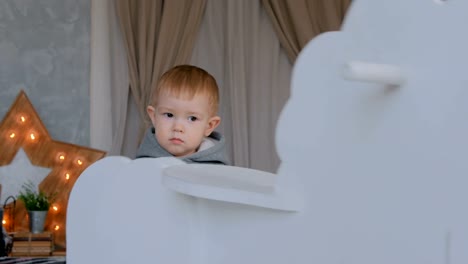 Niño-jugando-con-caballo-de-madera-mecedora