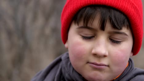 Retrato-de-niño-bonito-en-un-casquillo-rojo