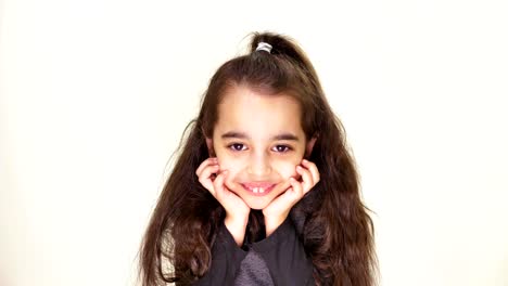 Little-cute-caucasian-girl,-smiling,-showing-an-emotion-of-expectation,-holding-her-head-with-her-hands,-portrait-white-background-50-fps