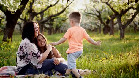 Beautiful-mother-and-her-little-daughter-and-son-outdoors