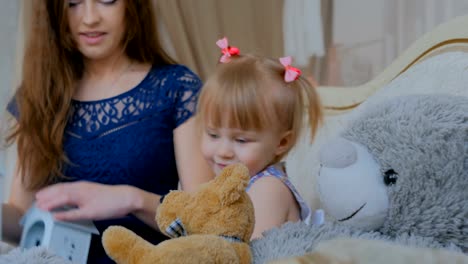 Joven-madre-y-su-hija-jugando-togerher-en-casa