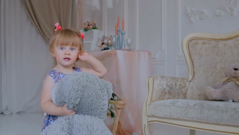 Portrait-von-lustiges-kleines-Mädchen-mit-Bär-Puppe-zu-Hause