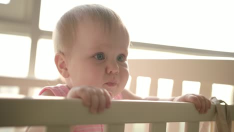 Cute-baby-standing-in-cot.-Cute-childhood.-Toddler-girl-in-crib