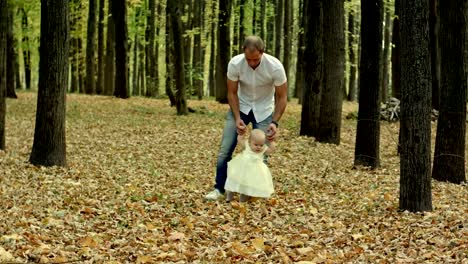 Father-and-his-baby-make-first-step-in-autumn-park