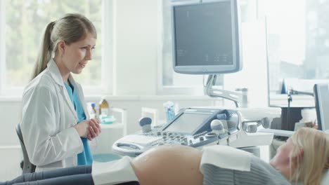 In-the-Hospital,-Pregnant-Woman-Getting-Sonogram-/-Ultrasound-Screening-/-Scan,-Obstetrician-Checks-Picture-of-the-Healthy-Baby-on-the-Computer-Screen.-Doctor-Explains-Details-of-the-Picture.