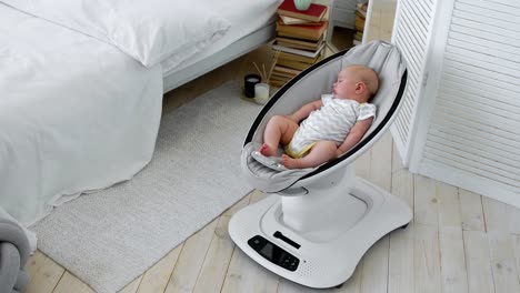 Baby-sleeps-in-a-rocking-chair-for-children-high-tech-design-in-white-bedroom