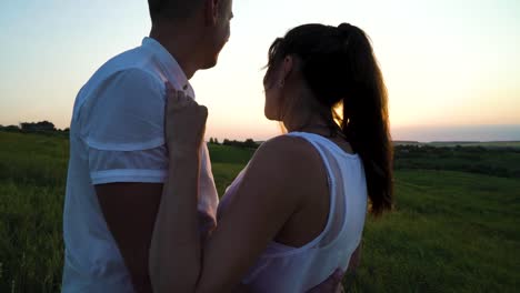 Romantic-young-happy-pregnant-couple-hugging-in-nature-at-sunset