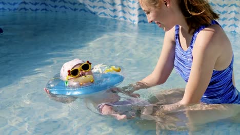 Una-mujer-con-un-bebé-nada-en-la-piscina