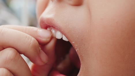 Close-up-of-little-girl-is-wiggle-her-milk-tooth.