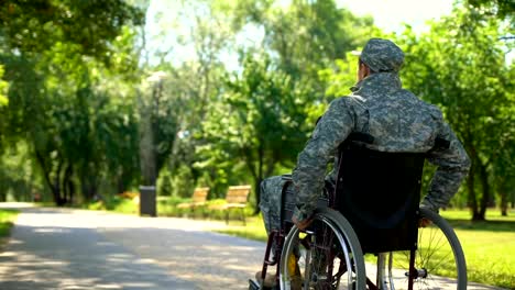 Injured-soldier-in-wheelchair-moving-in-park,-social-military-support,-pension