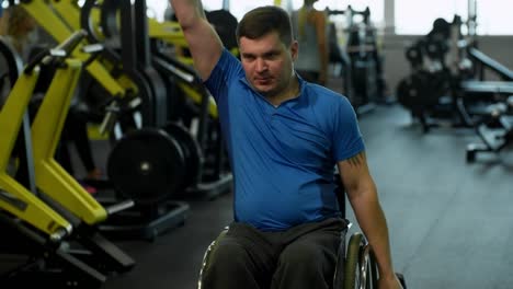 Hombre-en-silla-de-ruedas-de-entrenamiento-con-pesas-en-gimnasio