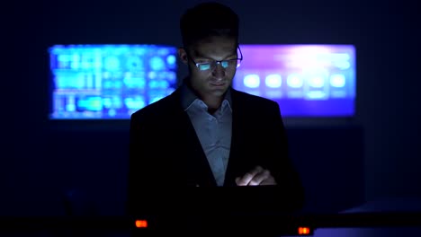 The-man-working-with-a-tablet-in-the-dark-room