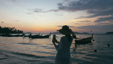 Beautiful-woman-taking-photos-with-smart-phone-technology-on-paradise-beach