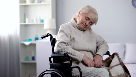 Old-wheelchaired-woman-sleeping-in-rehabilitation-center,-having-nap,-health