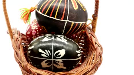 decorative-basket-with-painted-Easter-eggs-on-white-background