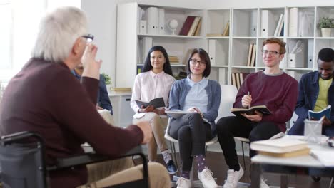 Männliche-Studenten-heben-Hand-während-der-Lektion