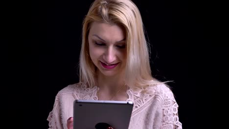 Closeup-shoot-of-middle-aged-caucasian-female-using-the-tablet-then-looking-at-camera-and-smiling