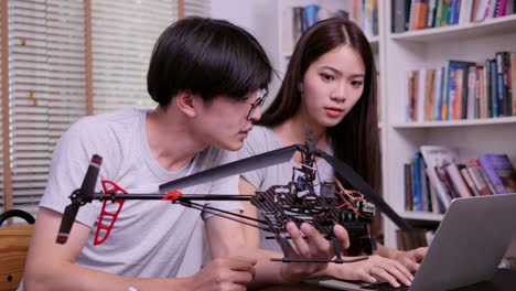 Man-and-Woman-try-to-fix-robot-together-at-school.-Technology-and-Education-concept.