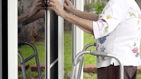 Elderly-woman-with-key-opening-front-door.