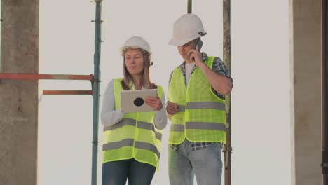 El-controlador-es-un-hombre-de-un-edificio-en-construcción-hablando-por-teléfono-con-la-administración-y-ha-discutido-con-el-ingeniero-y-arquitecto-mujer-progreso-de-la-construcción