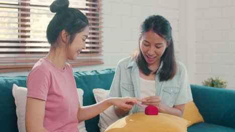 Asian-Lesbian-lgbtq-women-couple-propose-and-marriage-surprise-wear-wedding-ring-at-home.