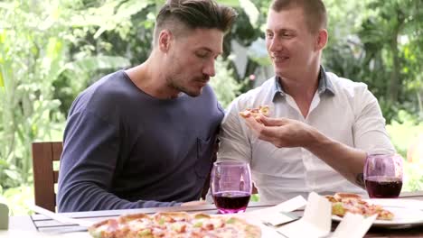 Gay-couple-having-pizza-for-lunch.-Sweet-talking-and-giving.