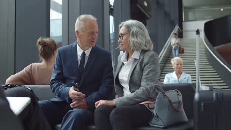 Pareja-Senior-Hablando-en-Aeropuerto