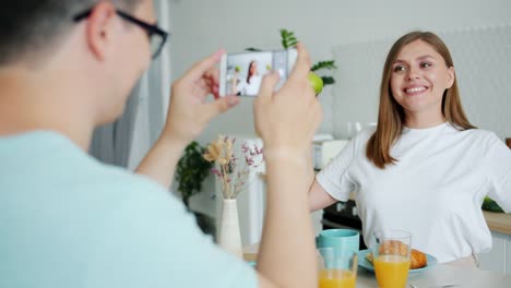 Zeitlupe-der-Dame-posiert-mit-Äpfeln,-wenn-Kerl-fotografieren-mit-smartphone