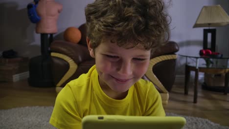 Niño-caucásico-absorbido-viendo-algo-divertido-en-la-pantalla-del-teléfono-inteligente.-Niño-alegre-mirando-la-pantalla-y-riendo.-Generación-Z,-internet,-tecnologías-modernas.-Cinema-4k-ProRes-HQ.