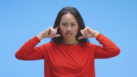 Young-woman-plugging-hear-ears-with-fingers