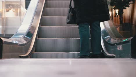 Piernas-de-personas-moviéndose-en-un-ascensor-de-escaleras-mecánicas-en-el-centro-comercial.-Pies-de-comprador-en-Escalera-Saltadora-en-el-Centro-Comercial