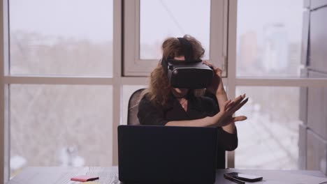 Young-american-woman-in-augmented-reality-glasses-moving-hands